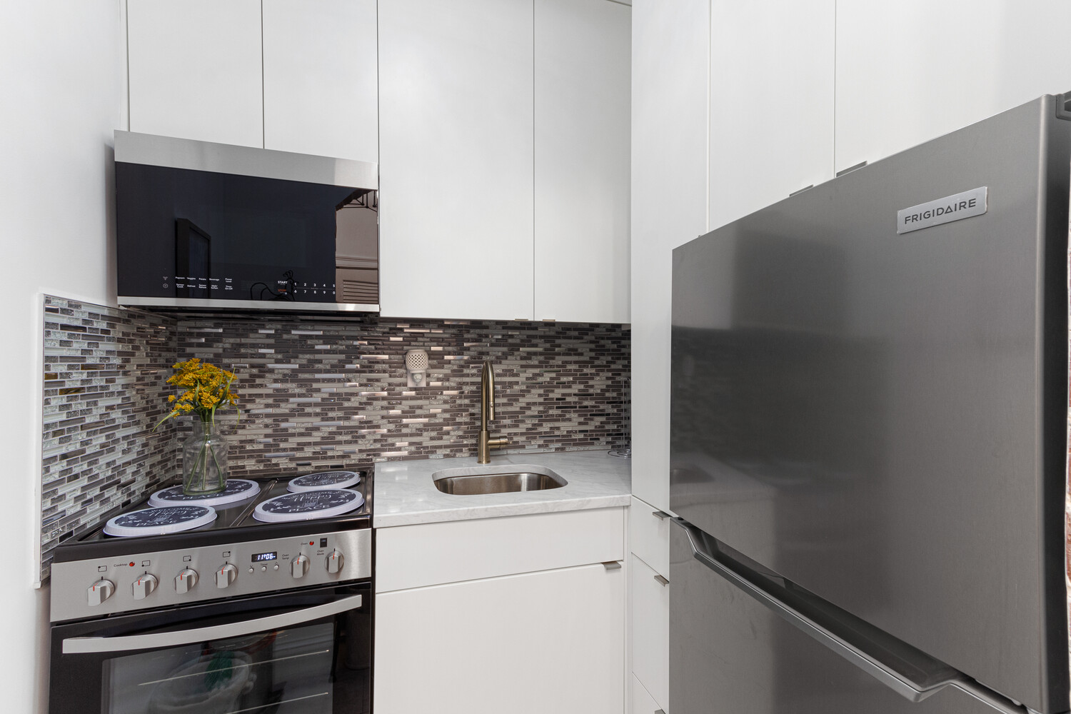 80 Park Avenue, Unit 6A Manhattan, NY 10016 - Photo 4 of 7 a kitchen with a stove and a microwave