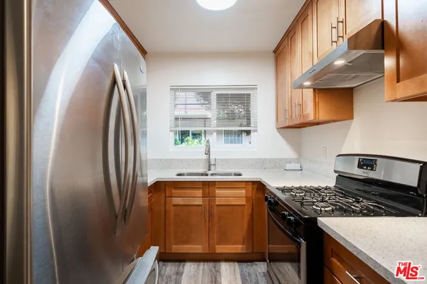 a kitchen with stainless steel appliances granite countertop a refrigerator and a sink