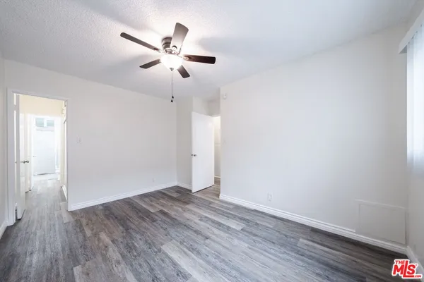 a view of empty room with wooden floor
