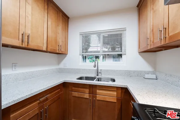 a kitchen with stainless steel appliances granite countertop a sink and a white cabinets
