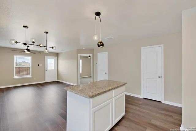 a kitchen with kitchen island granite countertop wooden cabinets and a sink