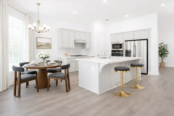 a kitchen with kitchen island a dining table chairs sink and cabinets