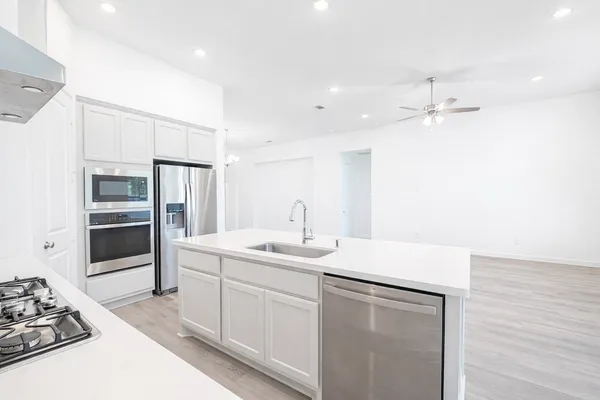 a kitchen with a sink appliances and cabinets