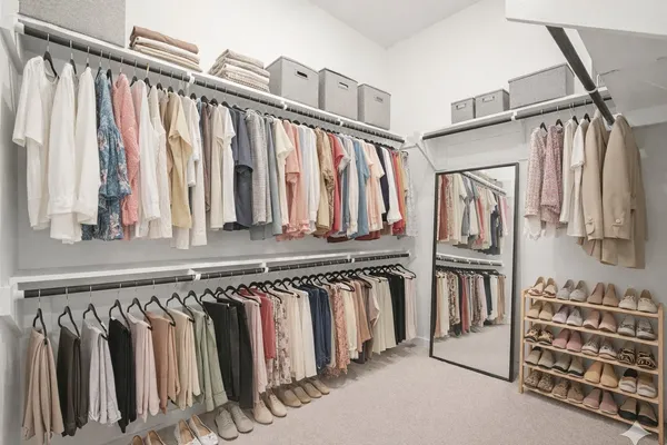 a view of walk in closet with clothes and shoes