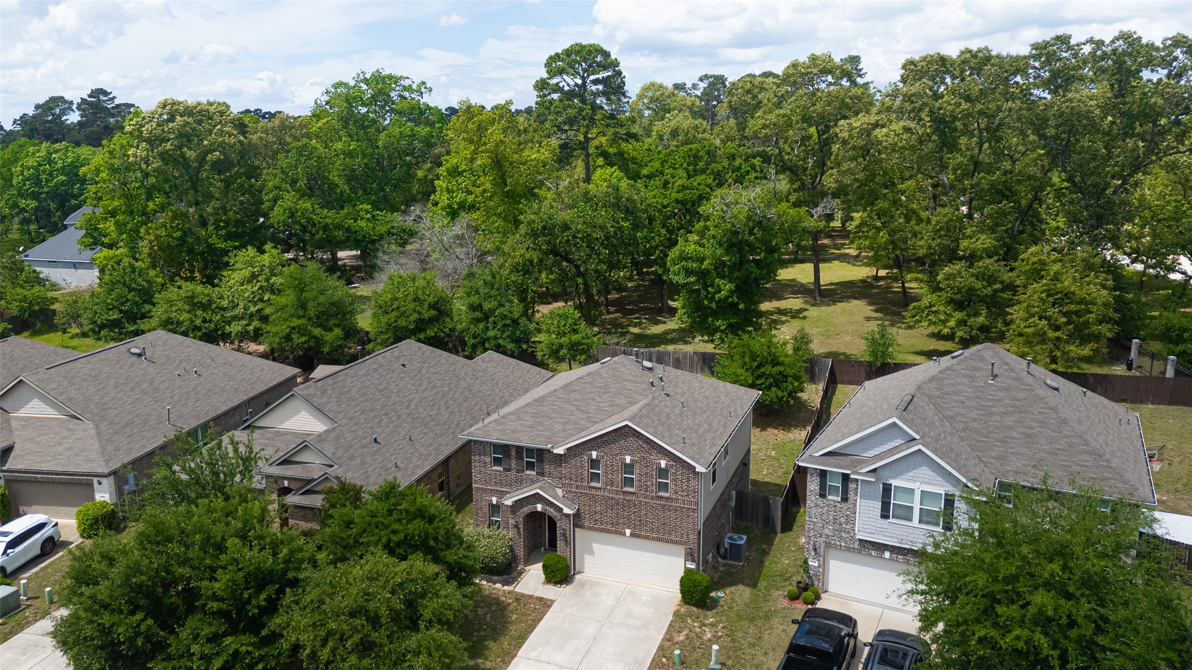 2107 Parnevik Place Conroe, TX 77304 - Photo 3 of 44 Enjoy a serene backyard escape with a fully fenced yard that opens to a stunning stretch of mature trees—your own private slice of nature just beyond the fence line.