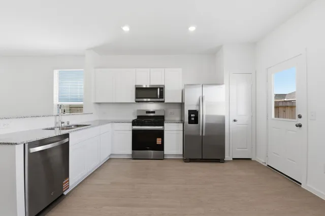 a kitchen with a sink stainless steel appliances and cabinets