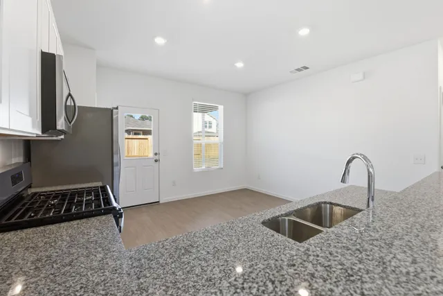 a kitchen with sink a faucet and appliances