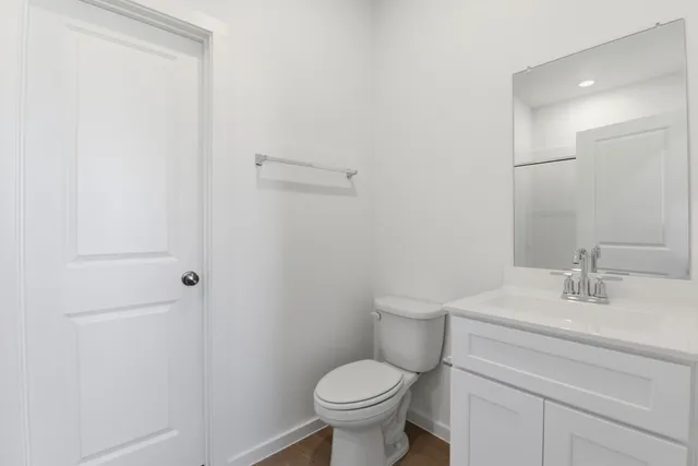 a bathroom with a toilet sink vanity and mirror