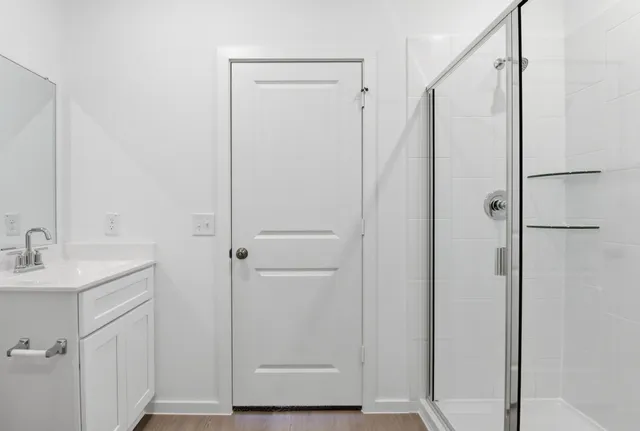 a bathroom with a shower sink and mirror