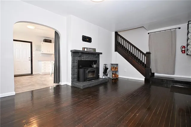 a view of empty room with wooden floor and fireplace