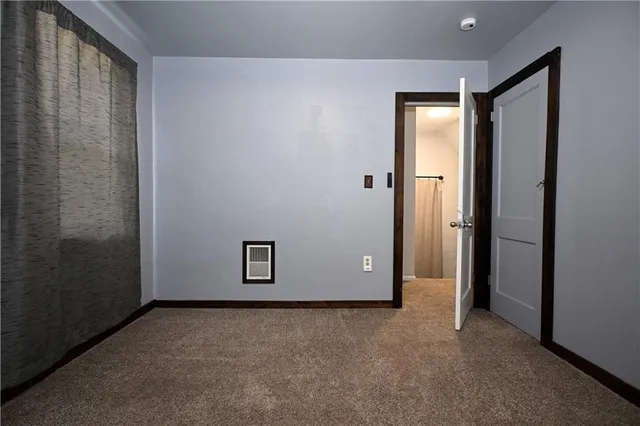 an empty room with closet and mirror