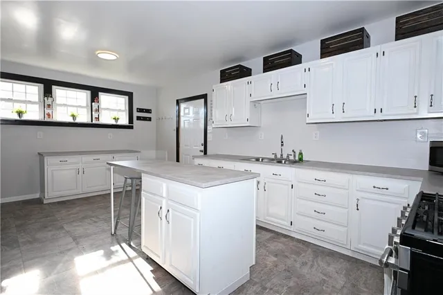 a kitchen with granite countertop white cabinets white stainless steel appliances a sink and dishwasher