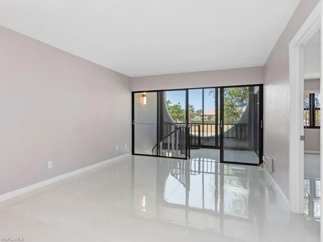 an empty room with sliding glass door and mountain view