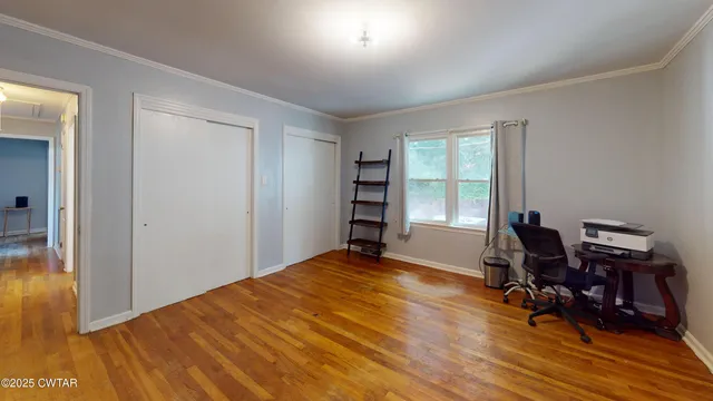 a workspace with wooden floor and a window