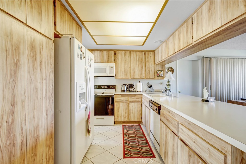 26490 McCall Boulevard Menifee, CA 92586 - Photo 4 of 14 a kitchen with a sink a refrigerator and cabinets