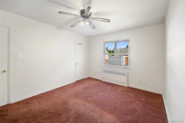 an empty room with fan and windows