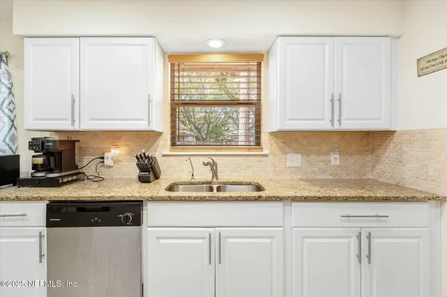 a kitchen with granite countertop white cabinets and white appliances
