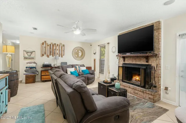 a living room with furniture a flat screen tv and a fireplace