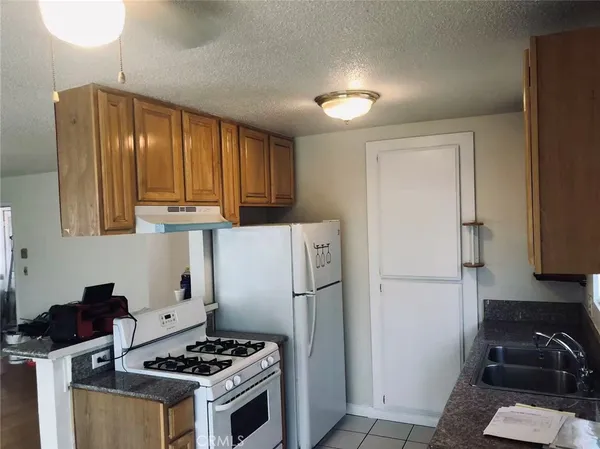 a kitchen with a refrigerator a stove a sink and cabinets