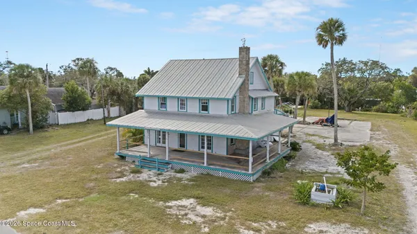 an aerial view of a house with swimming pool and furniture
