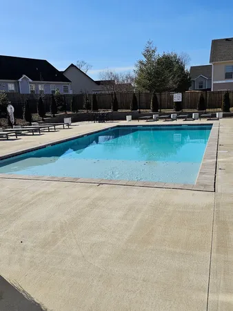 a view of a swimming pool with lawn chairs under an umbrella