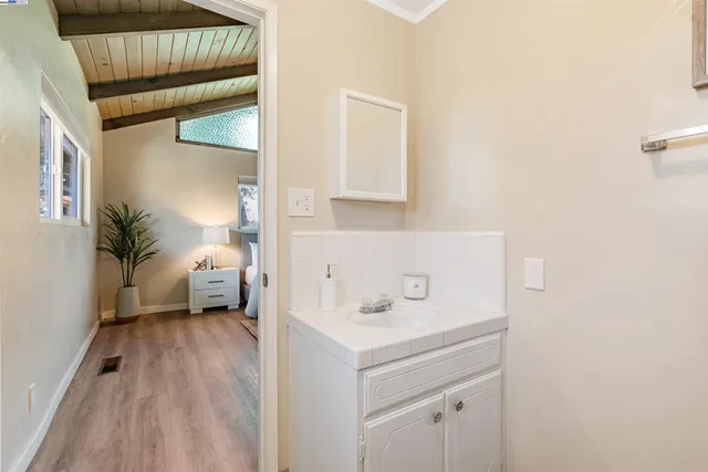 a dining room with furniture wooden floor a fireplace and a kitchen counter space