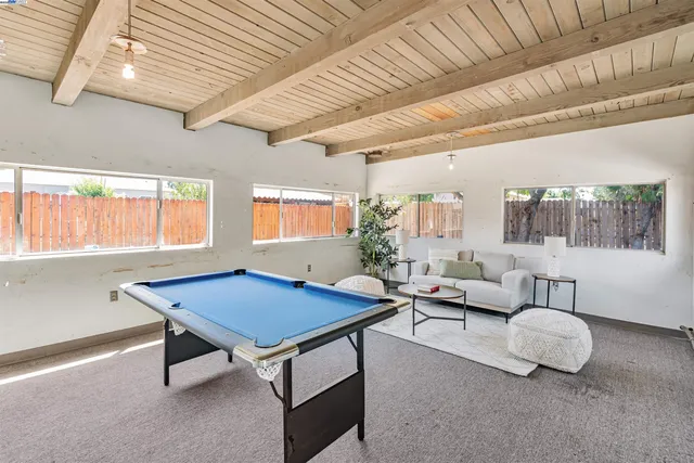 a living room with furniture pool table and a large window