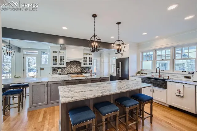 a kitchen with granite countertop a stove a sink a dining table and chairs