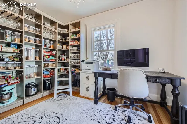 a view of a workspace with furniture and a window