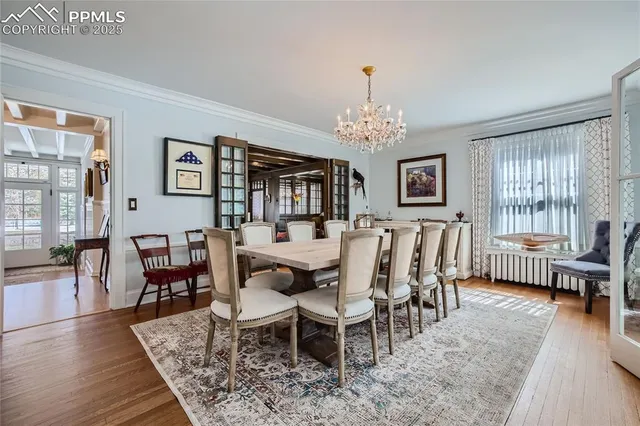 a view of a dining room with furniture a chandelier and wooden floor