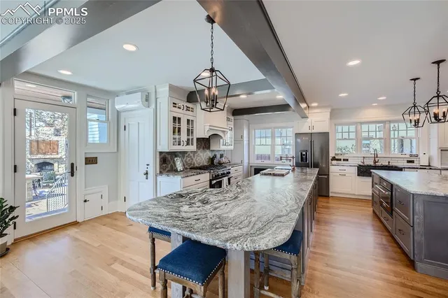 a dining room with stainless steel appliances granite countertop furniture wooden floor and a kitchen view