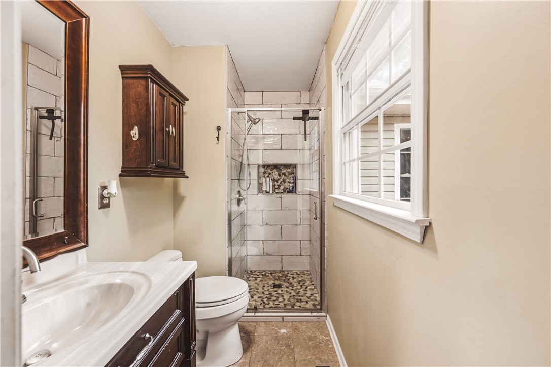 2001 Ridgeview Lane Seneca, SC 29678 - Photo 18 of 27 A well-lit bathroom featuring a tiled walk-in shower and a classic vanity with a framed mirror.