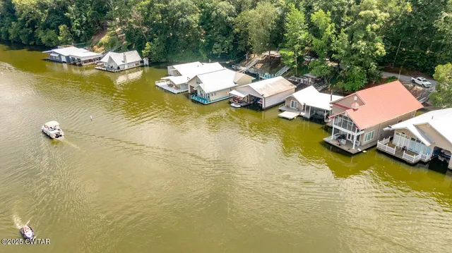 an aerial view of a house with a yard and lake view