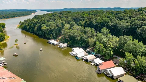 an aerial view of lake residential house with outdoor space and trees around