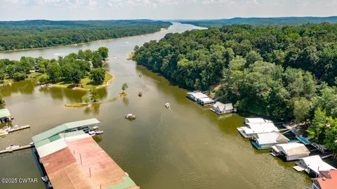 an aerial view of a house with a yard and lake view