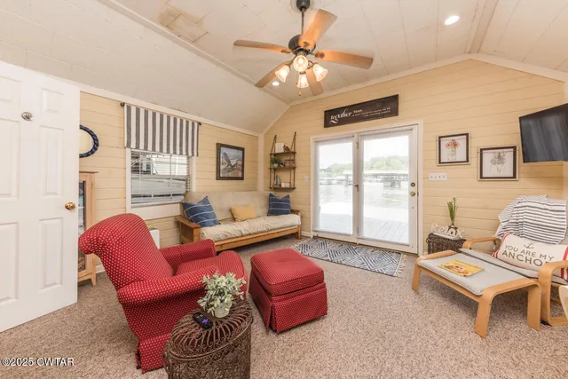 a living room with furniture a flat screen tv and a large window