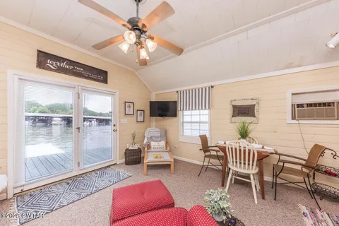 a living room with furniture a flat screen tv and a large window