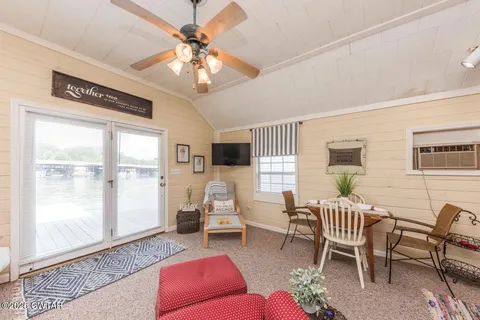 a living room with furniture a chandelier fan and a window