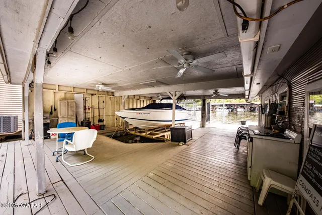a view of a patio with table and chairs with wooden floor and fence