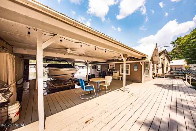 a view of a house with a barbeque and wooden stairs