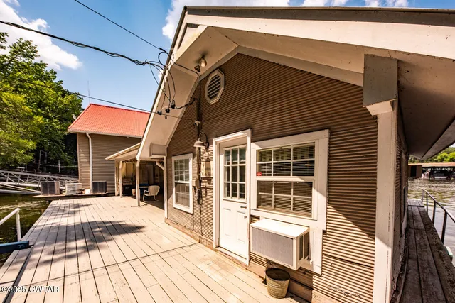 a small pool with lawn chairs under an umbrella