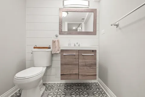 a bathroom with a toilet a sink and vanity