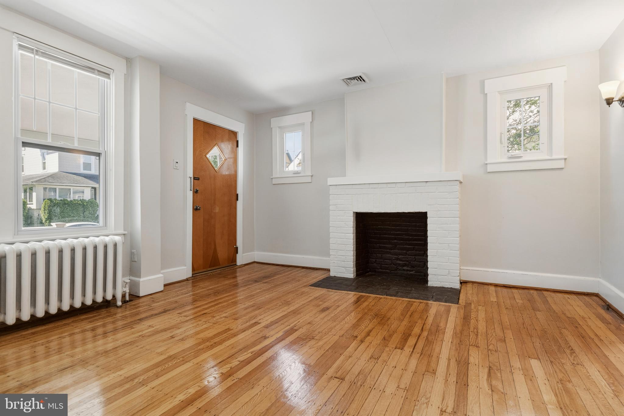 229 Wayne Avenue Narberth, PA 19072 - Photo 9 of 35 a view of an empty room with wooden floor and a window