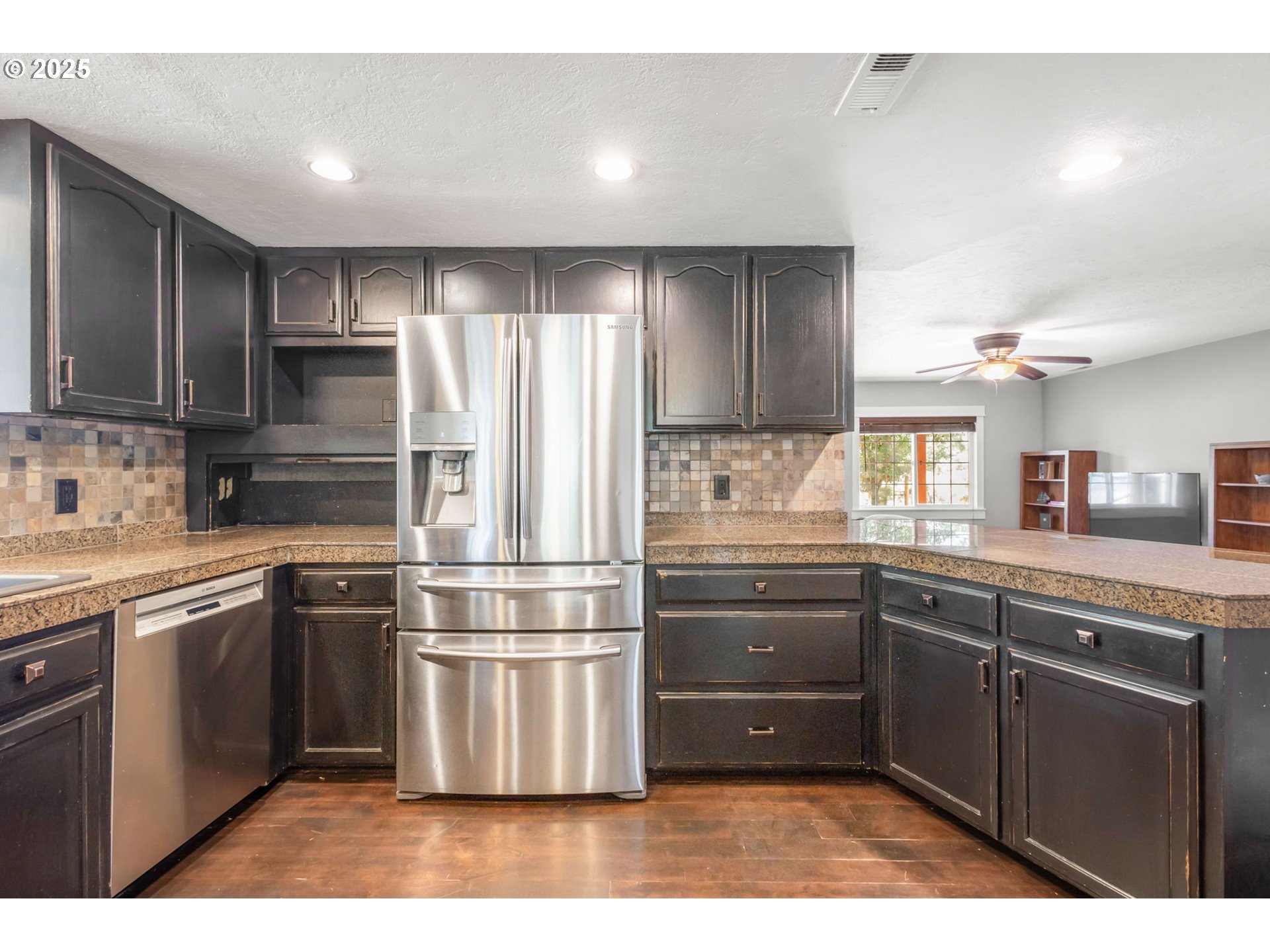 19723 Buck Canyon Road Bend, OR 97702 - Photo 13 of 48 a kitchen with stainless steel appliances granite countertop a refrigerator a sink dishwasher a stove with wooden cabinets