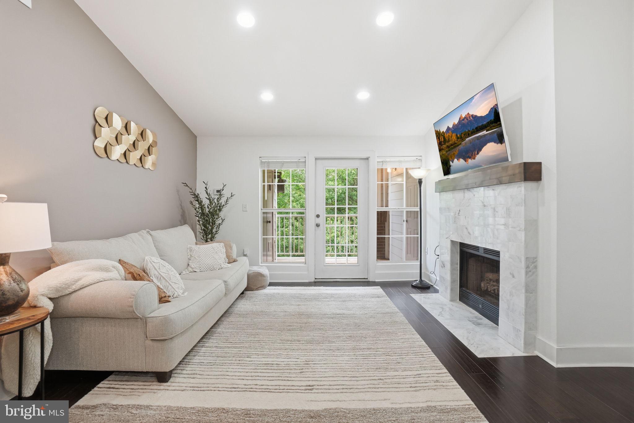 20960 Timber Ridge Terrace, Unit 303 Ashburn, VA 20147 - Photo 4 of 32 Marble fireplace with wood mantel