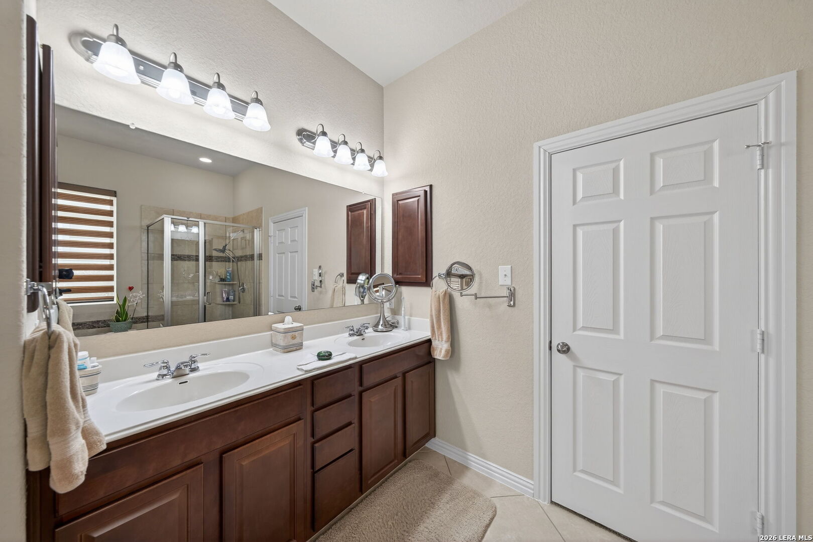 9108 Trail Stem Schertz, TX 78154 - Photo 18 of 26 a spacious bathroom with a double vanity sink a large mirror and a bathtub