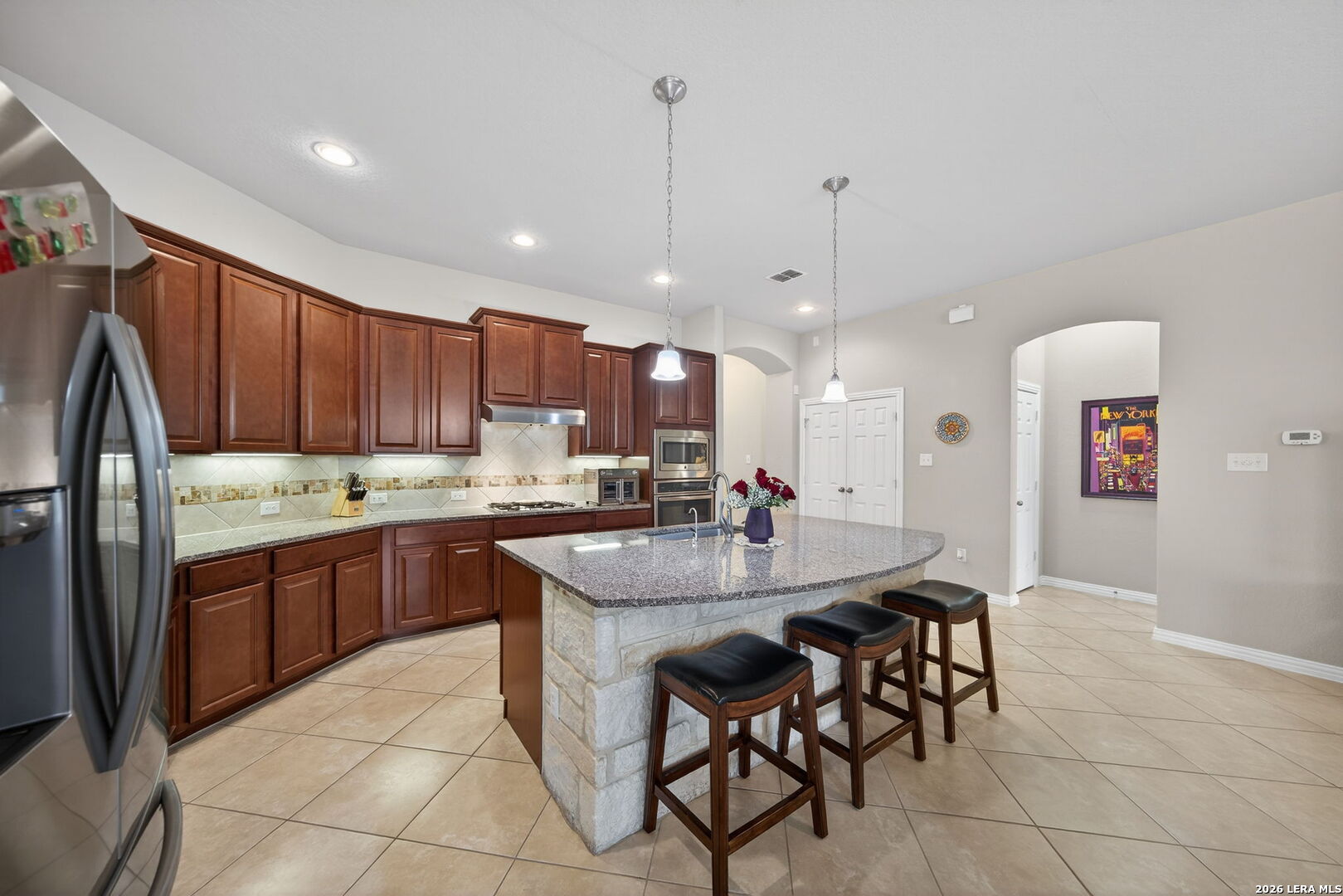 9108 Trail Stem Schertz, TX 78154 - Photo 8 of 26 a kitchen with stainless steel appliances granite countertop a sink a stove a dining table and chairs