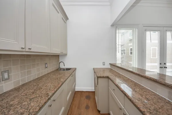 a kitchen with granite countertop white cabinets and a sink