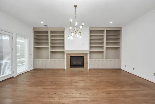 wooden floor fireplace and windows in an empty room