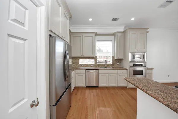 a kitchen with stainless steel appliances granite countertop a refrigerator and a sink